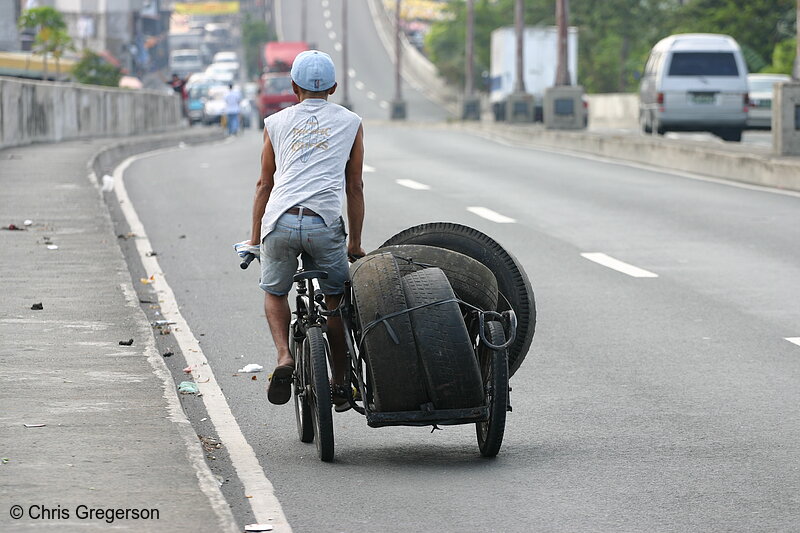 Photo of Man Hauling Tires on Manila Freeway(4581)