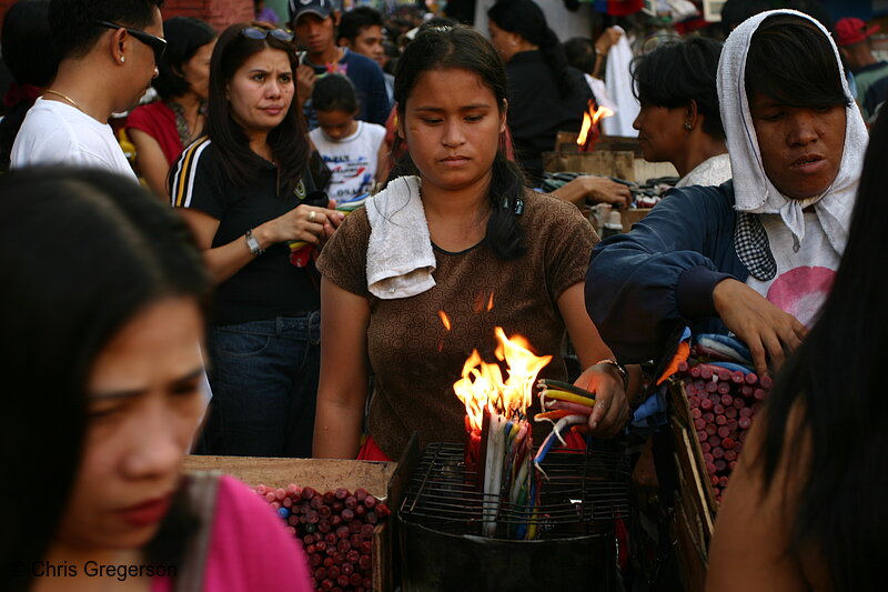 Photo of A Brown-Skinned Lady Lights Colorful Candles in the Middle of a Crowd(5505)
