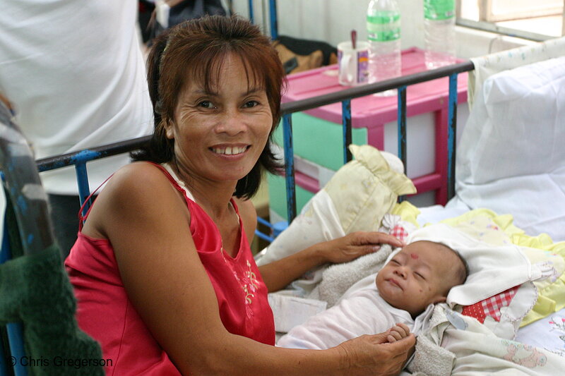 Photo of Smiling Grandmother Posing Beside a Sleeping Baby in the Nursery (5958)